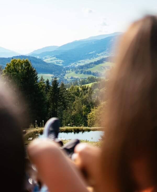 Aussicht auf das steirische Hügelland | © Urlaub am Bauernhof Steiermark / Daniel Gollner Blick auf Hügel in der Steiermark mit zwei Personen im Vordergrund | © Urlaub am Bauernhof Steiermark / Daniel Gollner