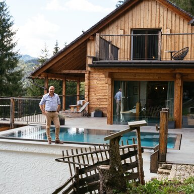 Holzhaus mit Balkon, Terrasse und Pool inmitten einer Waldlandschaft. Touristisches Feriendomizil mit modernem Erscheinungsbild und traditionellen Elementen. | © Urlaub am Bauernhof Steiermark / Daniel Gollner