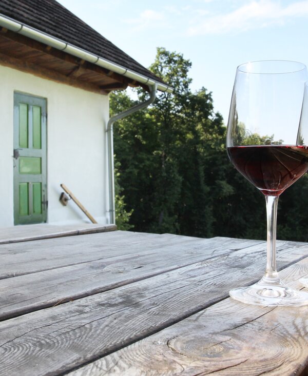2 Gläser mit Rotwein | © Urlaub am Bauernhof Burgenland / Wolfgang Pummer 2 Gläser mit Rotwein auf Holztisch vor dem Weinkeller | © Urlaub am Bauernhof Burgenland / Wolfgang Pummer