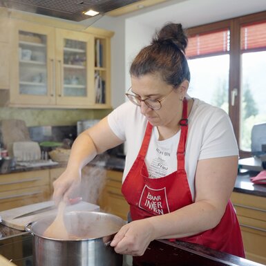 Gerlinde Weger steht beim Herd und kocht | © Daniel Gollner/ Urlaub am Bauernhof in Österreich