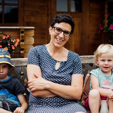 Frau und Kinder sitzen auf der Bank | © Urlaub am Bauernhof Kärnten / Daniel Gollner