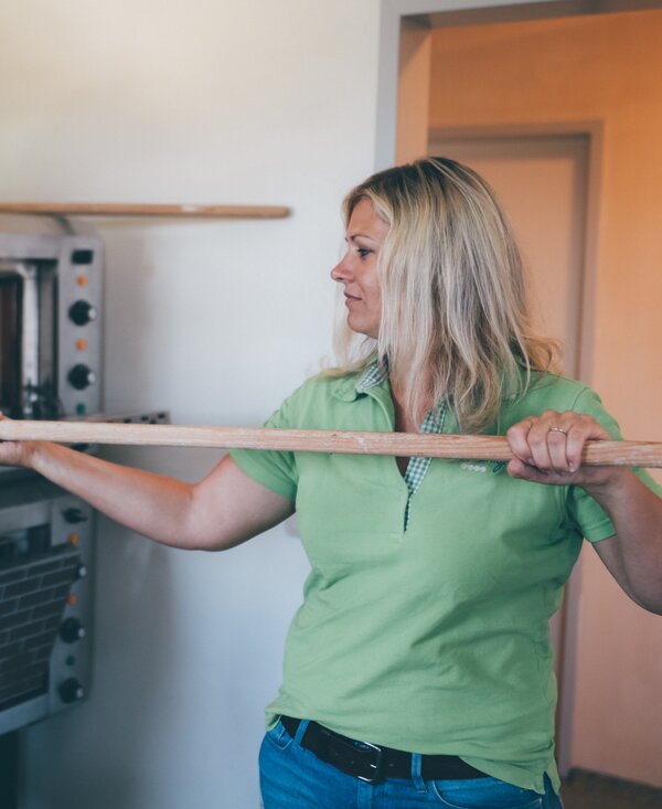 Frau backt Brot | © Urlaub am Bauernhof Kärnten / Daniel Gollner Frau schiebt das Brot in den Ofen | © Urlaub am Bauernhof Kärnten / Daniel Gollner