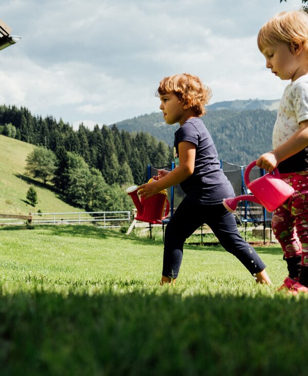 Kinder auf der Wiese | © Urlaub am Bauernhof Kärnten / Daniel Gollner Kinder mit Gießkannen auf der Wiese | © Urlaub am Bauernhof Kärnten / Daniel Gollner