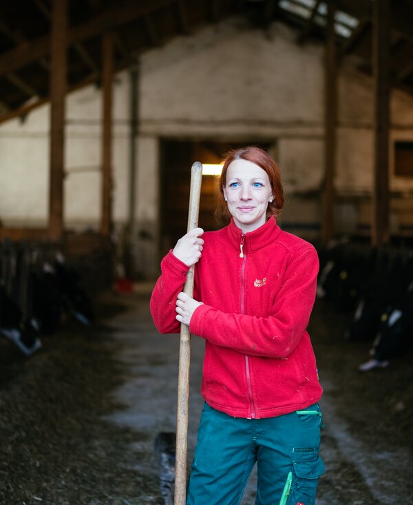 Kathi Borchardt | © Urlaub am Bauernhof Kärnten / Daniel Gollner Frau steht mit Mistgabel in der Hand vor dem Stall | © Urlaub am Bauernhof Kärnten / Daniel Gollner