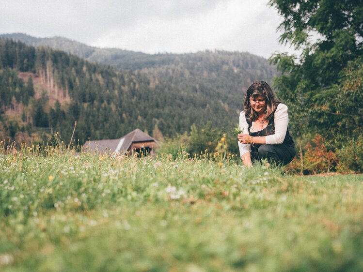 Frau kniet auf der Wiese | © Urlaub am Bauernhof Kärnten / Daniel Gollner