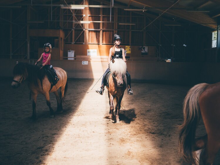 Frau reiten im Reitstall | © Urlaub am Bauernhof Kärnten / Daniel Gollner