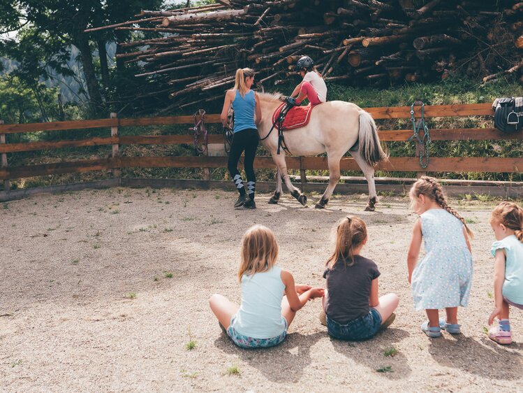 Frau führt Pferd im Viereck und Kinder schauen zu | © Urlaub am Bauernhof Kärnten / Daniel Gollner