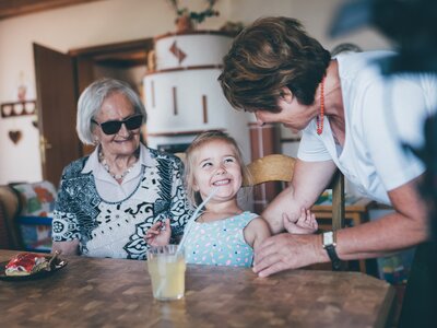 Oma, Frau und Mädchen | © Urlaub am Bauernhof Kärnten / Daniel Gollner Oma, Frau und Mädchen sitzen am Tisch | © Urlaub am Bauernhof Kärnten / Daniel Gollner