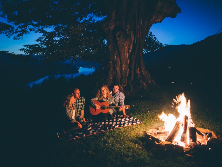 Familie sitzt mit der Gitarre beim Lagerfeuer | © Urlaub am Bauernhof Kärnten / Daniel Gollner