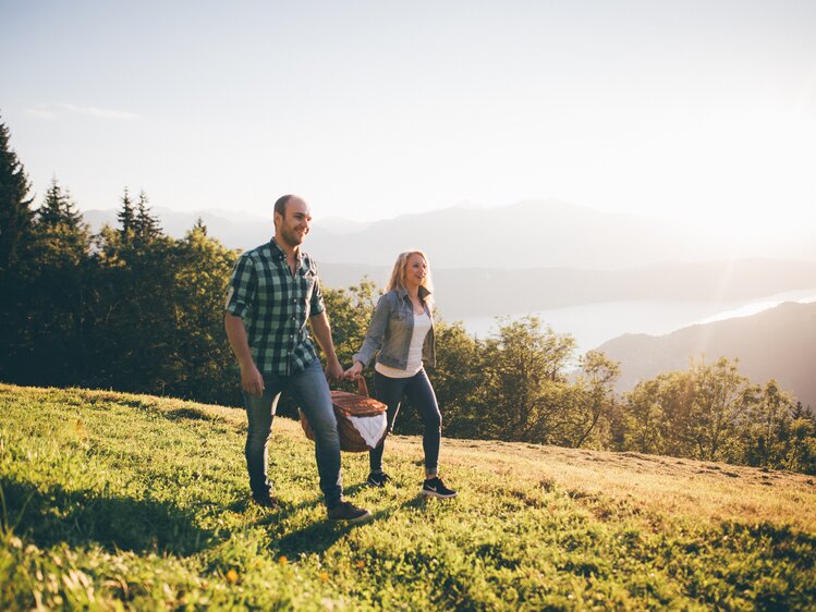Paar geht mit Picknickkorb auf der Wiese | © Urlaub am Bauernhof Kärnten / Daniel Gollner