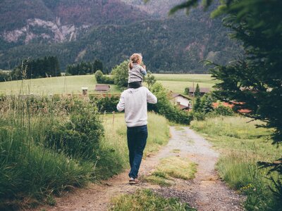 Mädchen sitzt auf Mannn | © Urlaub am Bauernhof Kärnten / Daniel Gollner Mädchen sitzt auf den Schultern des Mannes und sie spazieren am Weg | © Urlaub am Bauernhof Kärnten / Daniel Gollner