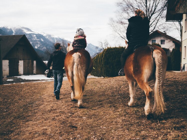 Frau und Kind reiten auf der Wiese | © Urlaub am Bauernhof Kärnten / Daniel Gollner