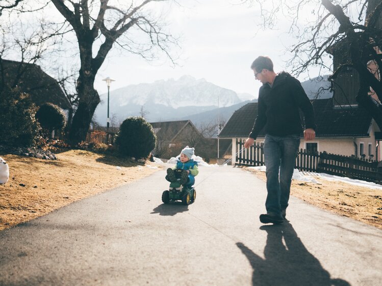 Kind und Mann mit dem Fahrzeug am Weg | © Urlaub am Bauernhof Kärnten / Daniel Gollner