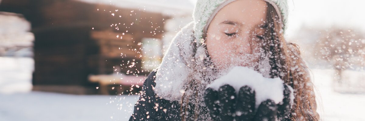 Mädchen pustet in den Schnee | © Urlaub am Bauernhof Kärnten / Daniel Gollner