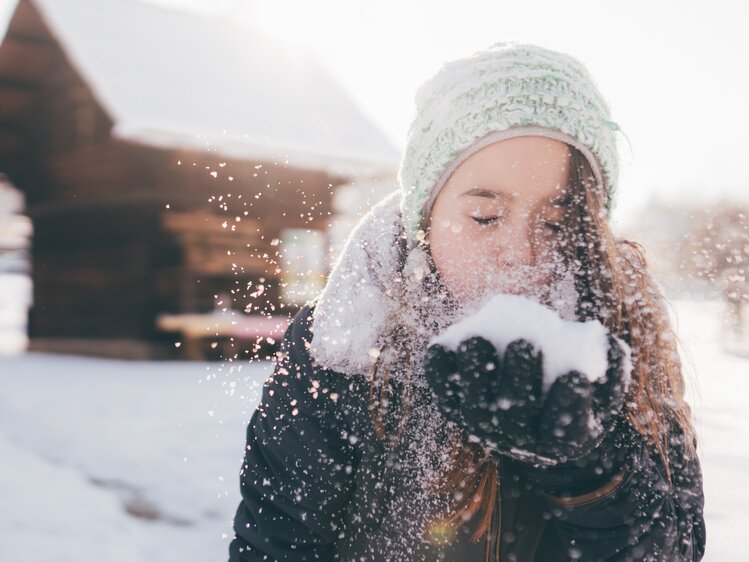 Mädchen pustet in den Schnee | © Urlaub am Bauernhof Kärnten / Daniel Gollner