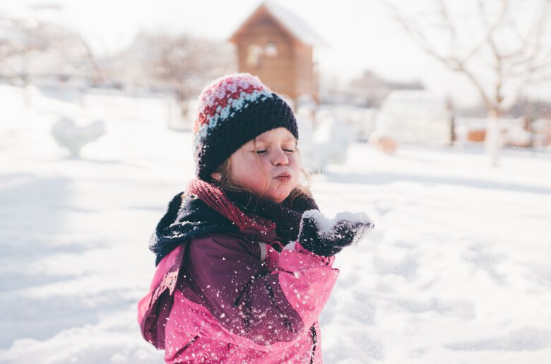 Mädchen pustet in den Schnee | © Urlaub am Bauernhof Kärnten/ Daniel Gollner