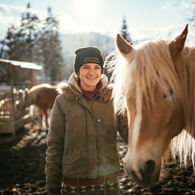 Frau steht mit Pferd im Auslauf | © Urlaub am Bauernhof Kärnten / Daniel Gollner