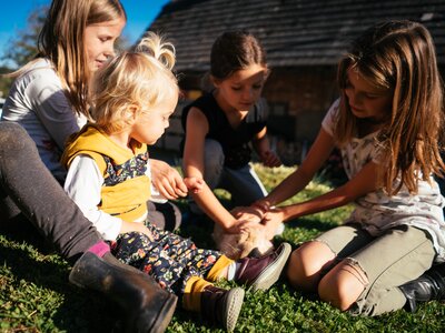 Kinder auf der Wiese streicheln den Hasen | © Urlaub am Bauernhof Kärnten / Daniel Gollner Kinder sitzen auf der Wiese und streicheln den Hasen | © Urlaub am Bauernhof Kärnten / Daniel Gollner