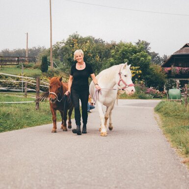 Frau führt Pferde am Weg | © Urlaub am Bauernhof Kärnten / Daniel Gollner