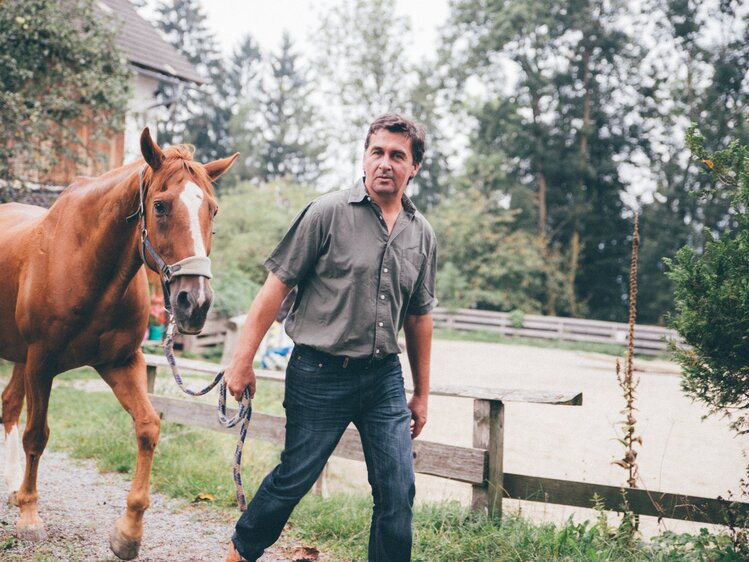 Mann führt das Pferd am Weg | © Urlaub am Bauernhof Kärnten / Daniel Gollner