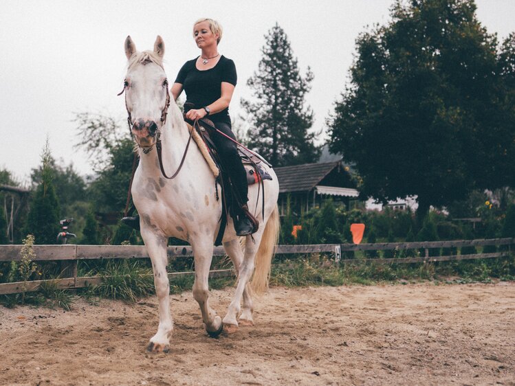 Frau reitet auf Pferd im Viereck | © Urlaub am Bauernhof Kärnten / Daniel Gollner