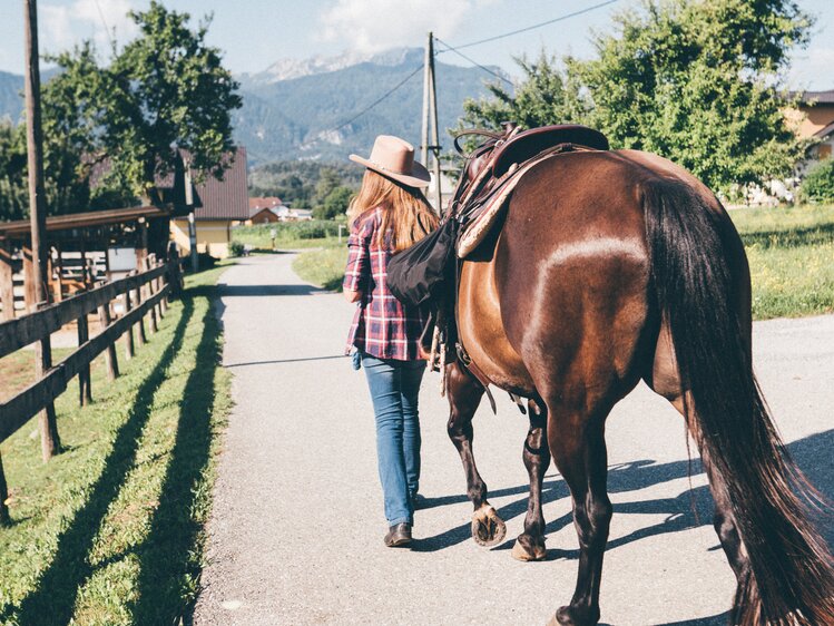 Frau führt das Pferd am Weg | © Urlaub am Bauernhof Kärnten / Daniel Gollner