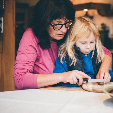 Frau und Mädchen schneiden etwas am Brett | © Urlaub am Bauernhof Kärnten / Daniel Gollner