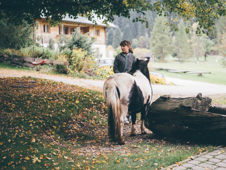 Mädchen und Pony beim Brunnen | © Urlaub am Bauernhof Kärnten/ Daniel Gollner