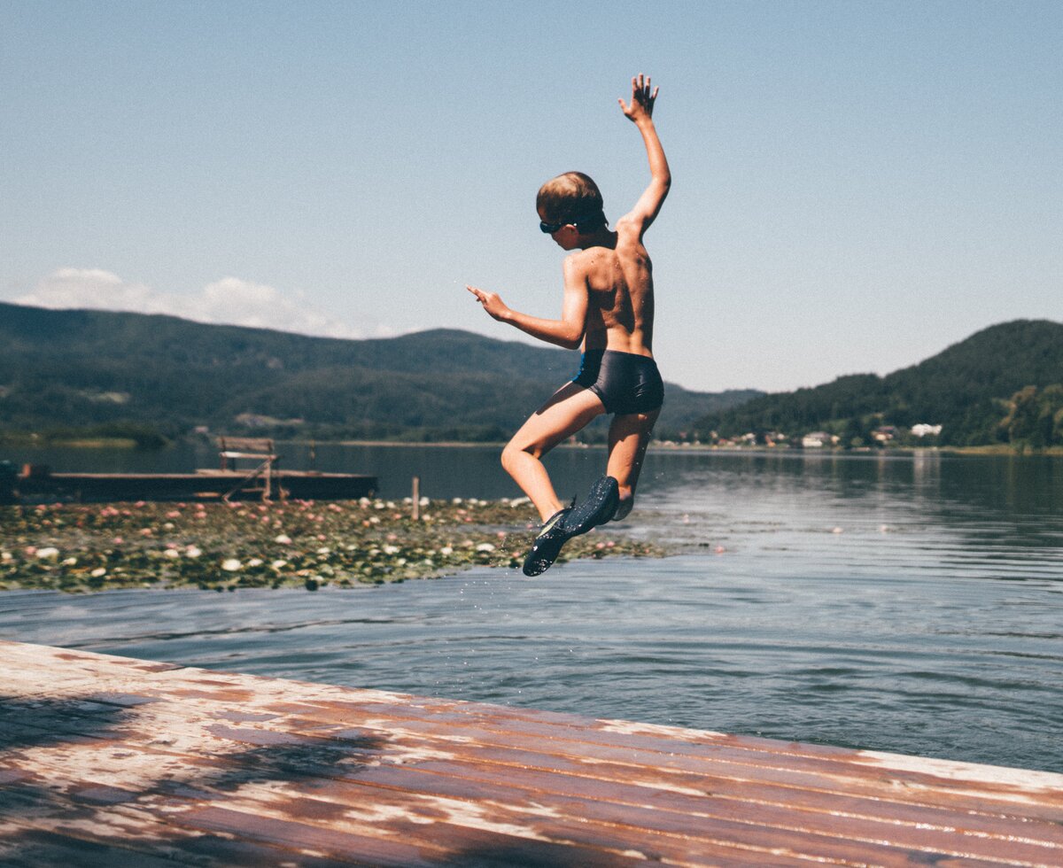 Bub springt vom Steg in den See | © Urlaub am Bauernhof Kärnten/ Daniel Gollner