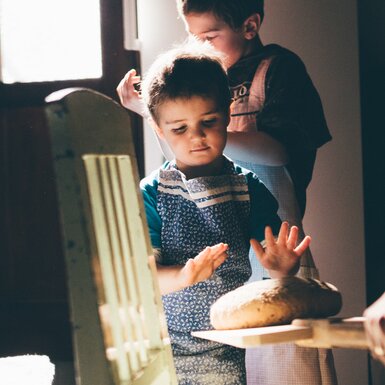Bub hat die Hände über dem Brot | © Urlaub am Bauernhof Kärnten/ Daniel Gollner