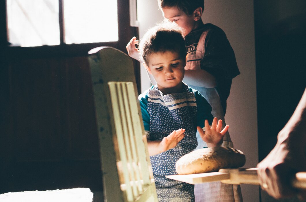 Bub hat die Hände über dem Brot | © Urlaub am Bauernhof Kärnten/ Daniel Gollner