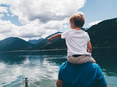 Kind zeigt auf den See | © Urlaub am Bauernhof Kärnten/ Daniel Gollner Kind sitzt auf den Schultern und zeigt auf den See | © Urlaub am Bauernhof Kärnten/ Daniel Gollner