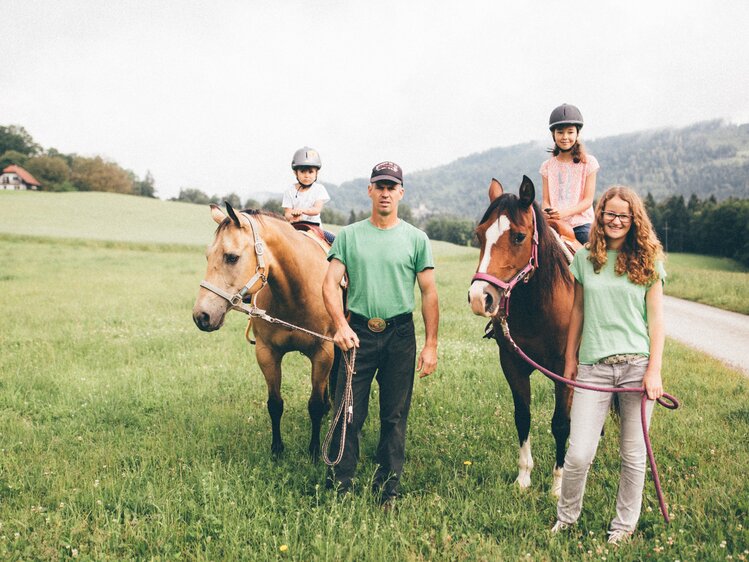 Familie steht mit den Pferden auf der Wiese | © Urlaub am Bauernhof Kärnten/ Daniel Gollner