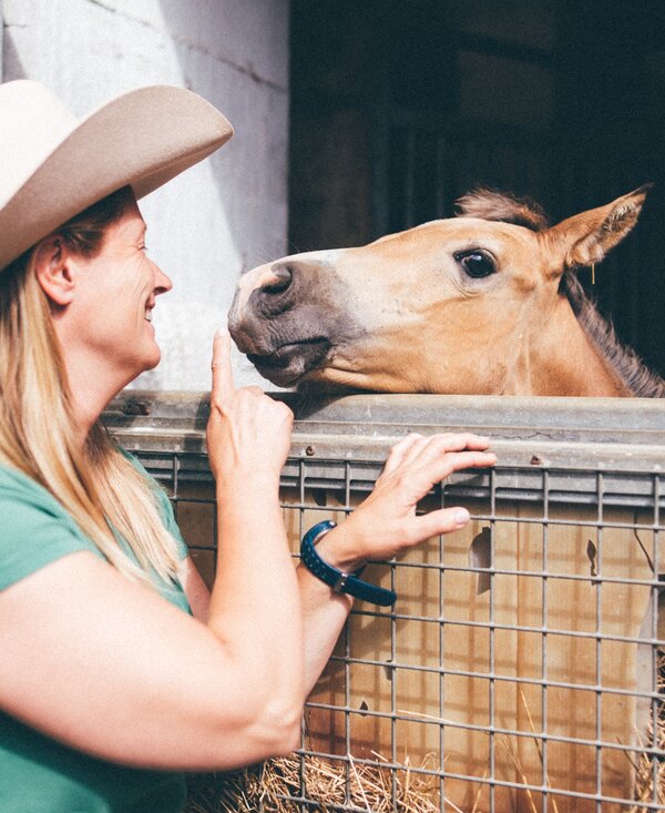Frau bei Pferd | © Urlaub am Bauernhof Kärnten / Daniel Gollner Frau steht vor der Pferdebox und Pferd schaut heraus | © Urlaub am Bauernhof Kärnten / Daniel Gollner