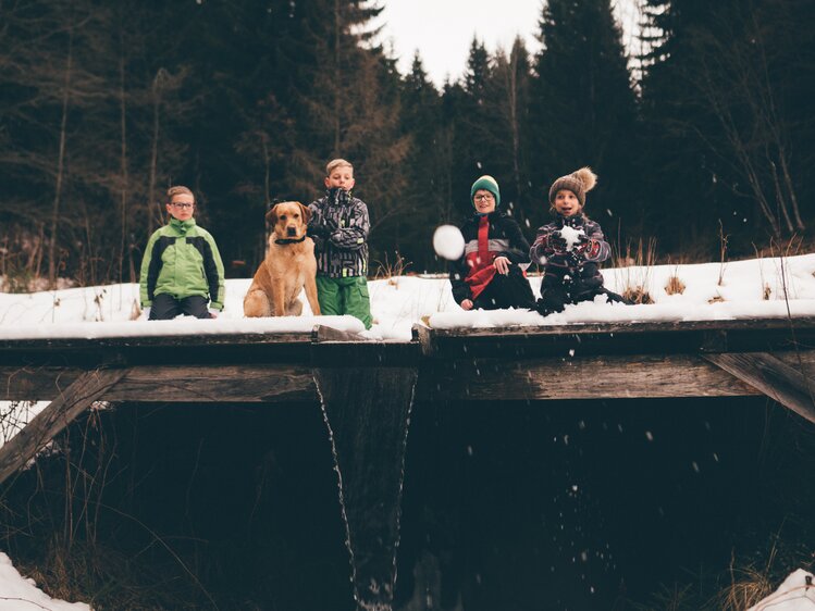 Kinder und Hund knien im Schnee | © Urlaub am Bauernhof Kärnten / Daniel Gollner