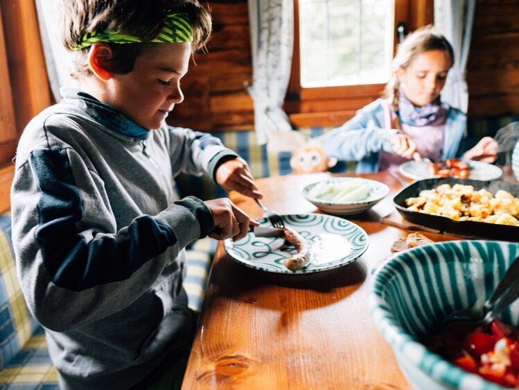 Bub und Mädchen essen am Tisch | © Urlaub am Bauernhof Kärnten/ Daniel Gollner