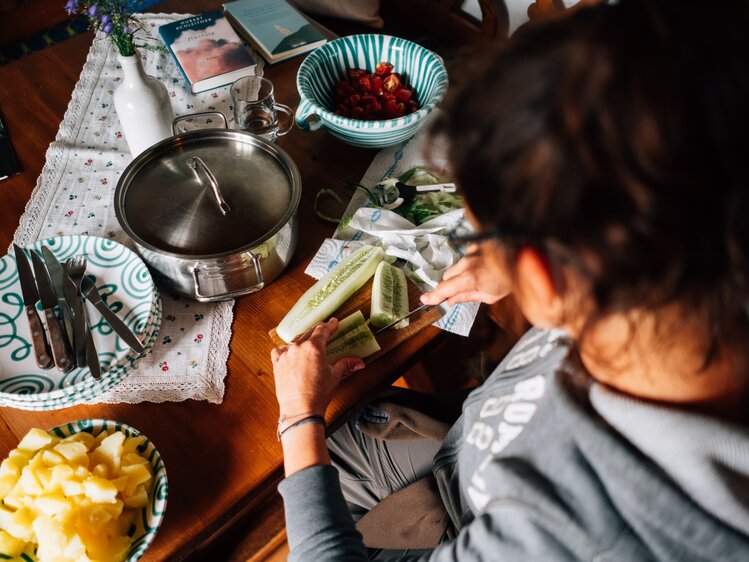 Frau schneidet das Essen auf | © Urlaub am Bauernhof Kärnten/ Daniel Gollner