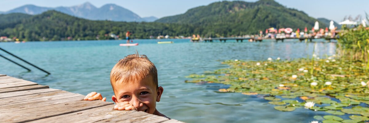 Kind schaut am Steg aus dem Klopeinersee | © Tourismusregion Klopeiner See - Südkärnten GmbH / Franz Gerdl