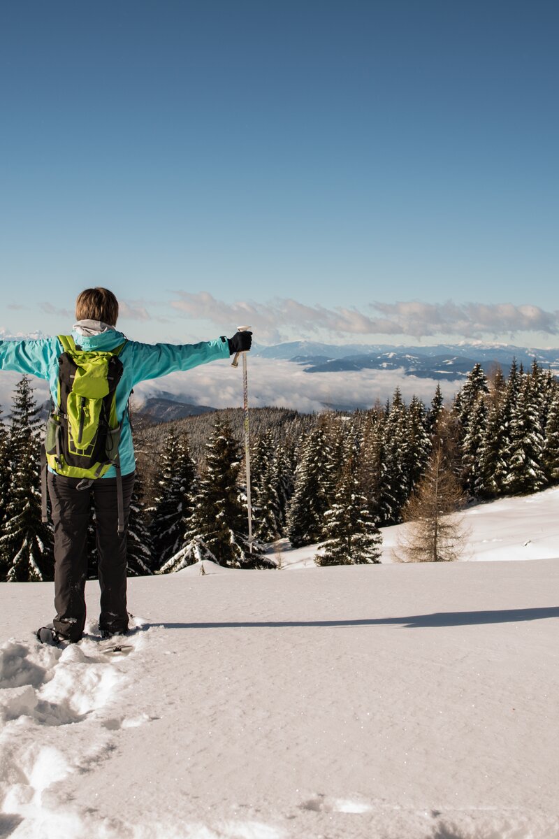 Schneeschuhwandern auf der Saualpe | © Tourismusregion Mittelkärnten  Schneeschuhwanderin steht im Tiefschnee und hebt die Arme | © Tourismusregion Mittelkärnten