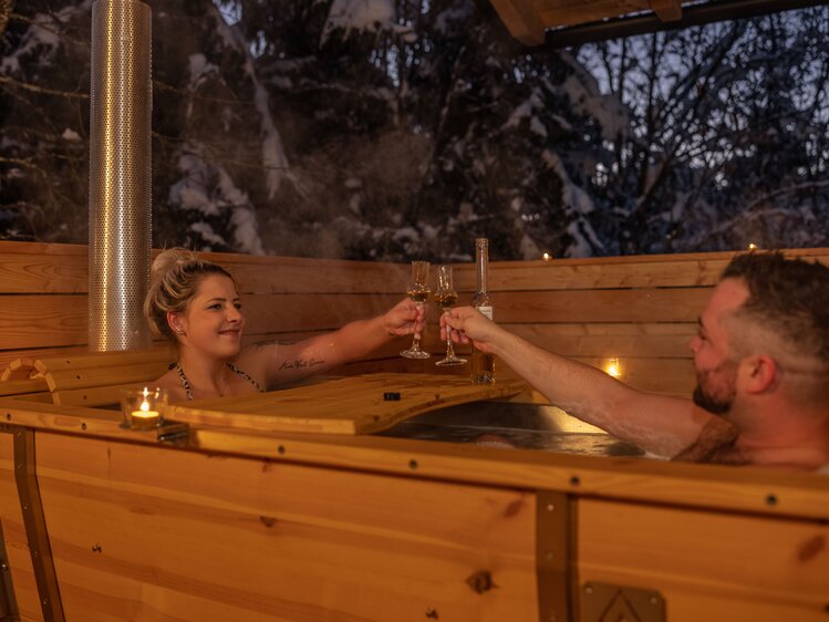 Paar trinkt etwas in der Holzbadewanne am Balkon | © Urlaub am Bauernhof Kärnten/ Achim Mandler