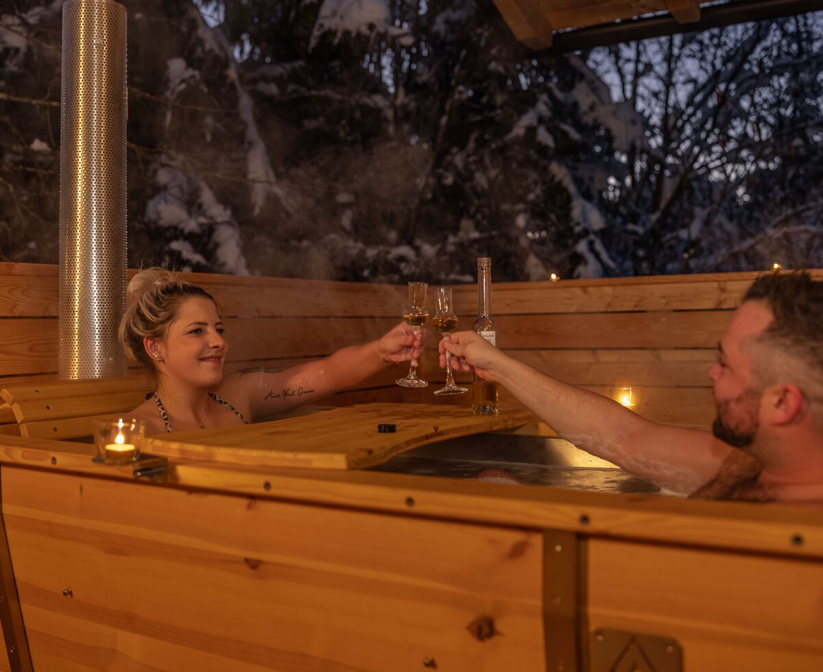 Paar in der Holzbadewanne | © Urlaub am Bauernhof Kärnten/ Achim Mandler Paar trinkt etwas in der Holzbadewanne am Balkon | © Urlaub am Bauernhof Kärnten/ Achim Mandler
