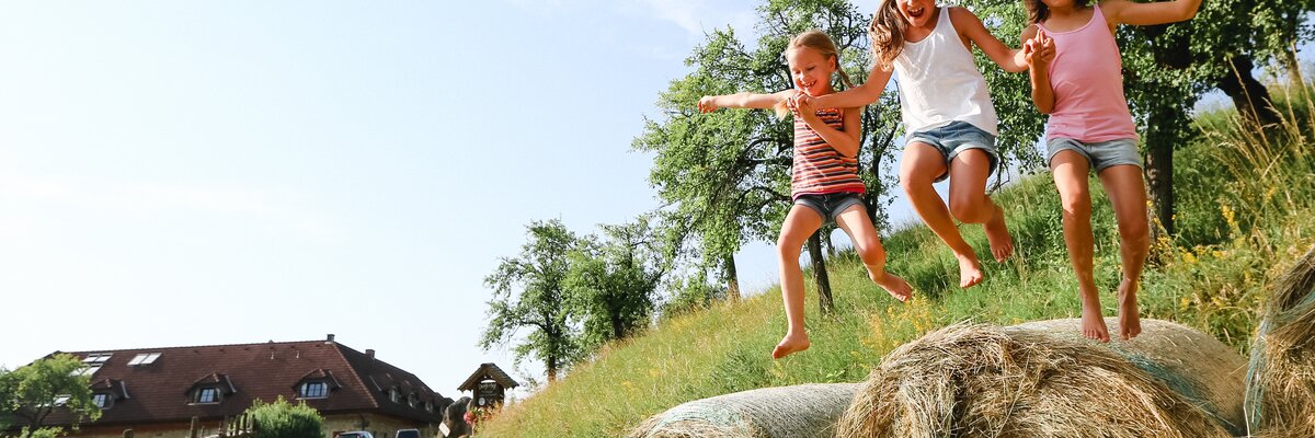 Mädchen springen von Strohballen | © Niederösterreich Werbung / schwarz-koenig.at