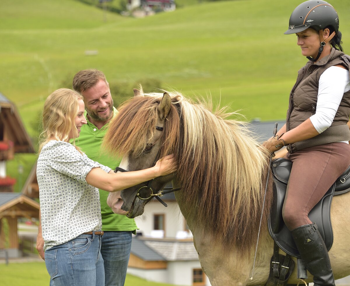 Pferdeerlebnis am Bauernhof | © Urlaub am Bauernhof Oberösterreich / Ralph Fischbacher Paar streichelt ein Pferd, auf dem eine Reiterin sitzt | © Urlaub am Bauernhof Oberösterreich / Ralph Fischbacher