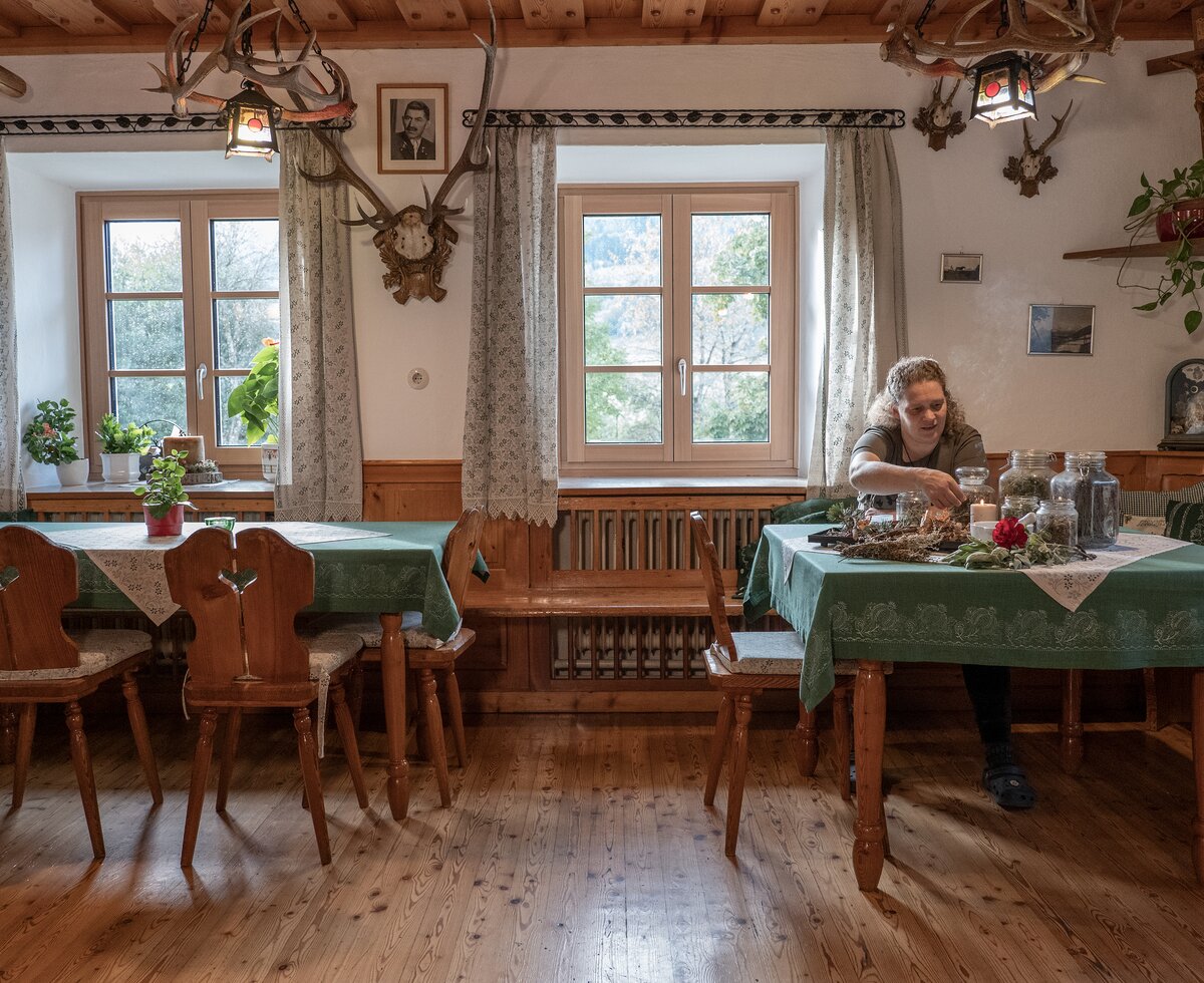 Traditionelle Stube und Räucherwerk am Ferienhof Zamsegg | © Oberösterreich Tourismus GmbH / Martin Fickert Bäuerin sitzt in traditioneller Stube mit Räucherwerk am Ferienhof Zamsegg in Vorderstoder, Nationalparkregion Kalkalpen | © Oberösterreich Tourismus GmbH / Martin Fickert