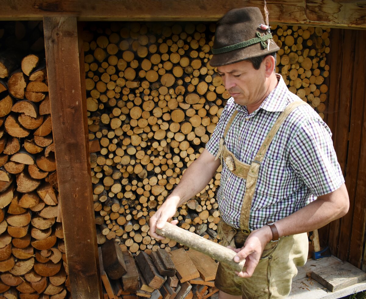 Holz, Ausgangsstoff für viele Zwecke | © Urlaub am Bauernhof Oberösterreich / Harald Puchegger Bauer zeigt ein Stück Holz her | © Urlaub am Bauernhof Oberösterreich / Harald Puchegger