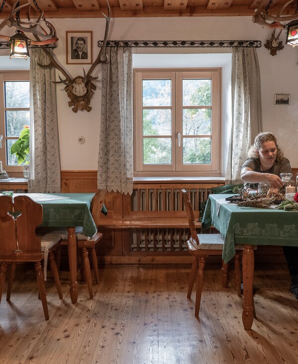 Traditionelle Stube und Räucherwerk am Ferienhof Zamsegg | © Oberösterreich Tourismus GmbH / Martin Fickert Bäuerin sitzt in traditioneller Stube mit Räucherwerk am Ferienhof Zamsegg in Vorderstoder, Nationalparkregion Kalkalpen | © Oberösterreich Tourismus GmbH / Martin Fickert