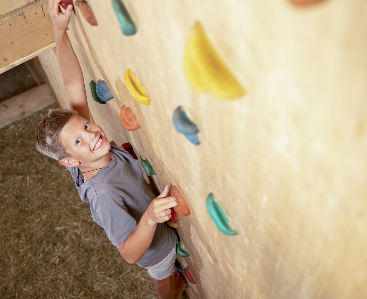 Kletterwand im Heustadl | © Urlaub am Bauernhof Oberösterreich / Andreas Hofer Bub klettert an einer Kletterwand im Heustadl | © Urlaub am Bauernhof Oberösterreich / Andreas Hofer