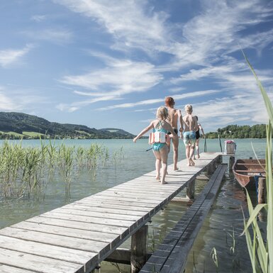 Sommerurlaub und Badespaß am See | © Urlaub am Bauernhof Oberösterreich / Robert Maybach Kinder laufen im Sommer auf einem Steg zum Baden direkt am See | © Urlaub am Bauernhof Oberösterreich / Robert Maybach