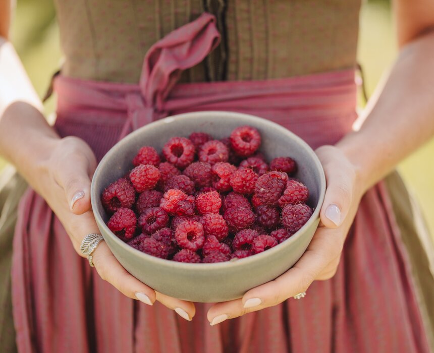 Frau mit Schale Himbeeren in der Hand | © Urlaub am Bauernhof Oberösterreich / Footprints Fotografie - cookingCatrin