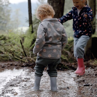 Kinder stehen mit Gummistiefeln in einer Lacke im Wald | © Urlaub am Bauernhof / Daniel Gollner